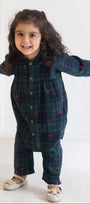 Child wearing a dark blue plaid outfit with red heart patterns on a white background