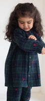 Child wearing a dark blue plaid dress with red accents against a white background