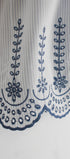 Close-up of a lace trim with blue floral patterns on a white background