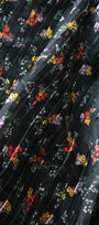 Close-up of pleated fabric with floral pattern on a black background