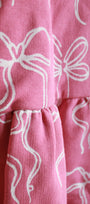 Close-up of pink fabric with white bow patterns
