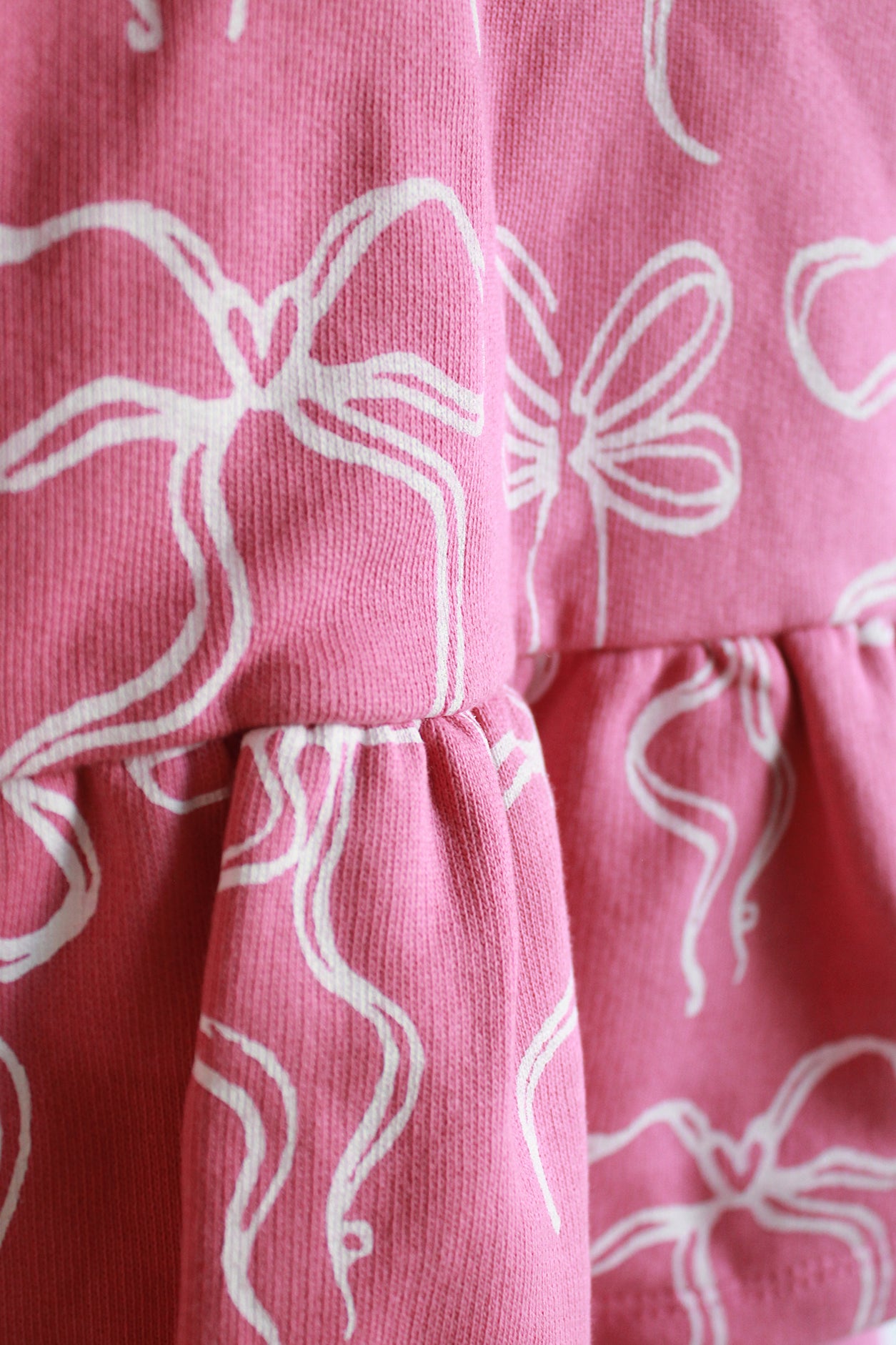 Close-up of pink fabric with white bow patterns