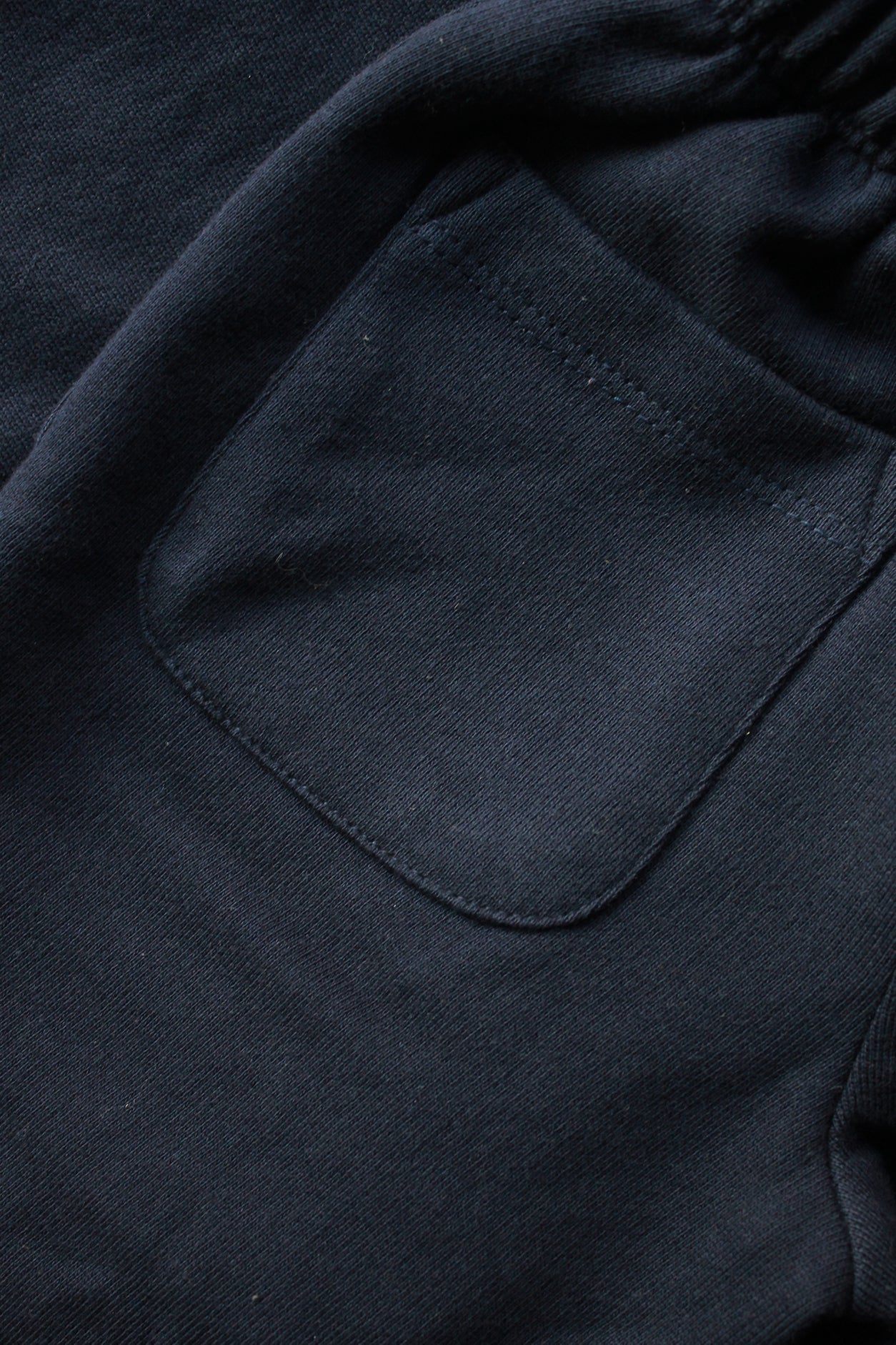 Close-up of a dark blue fabric with a pocket detail